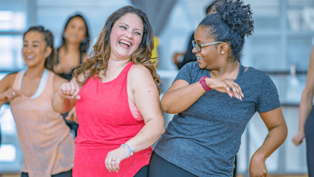 two women bumping hips in a group fitness class